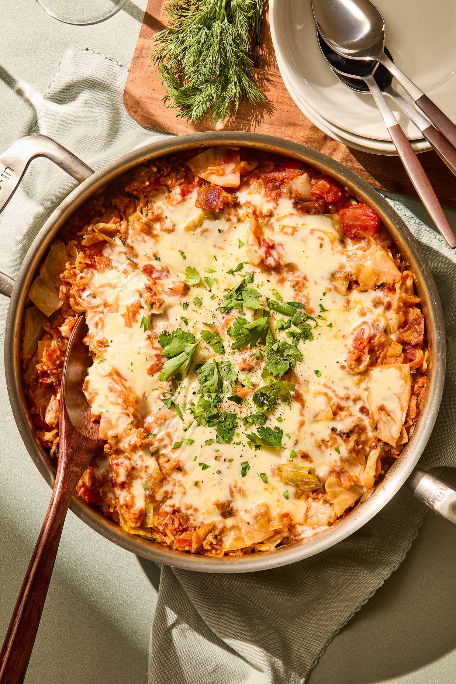 Parsley on top of melted cheese on a cabbage skillet.
