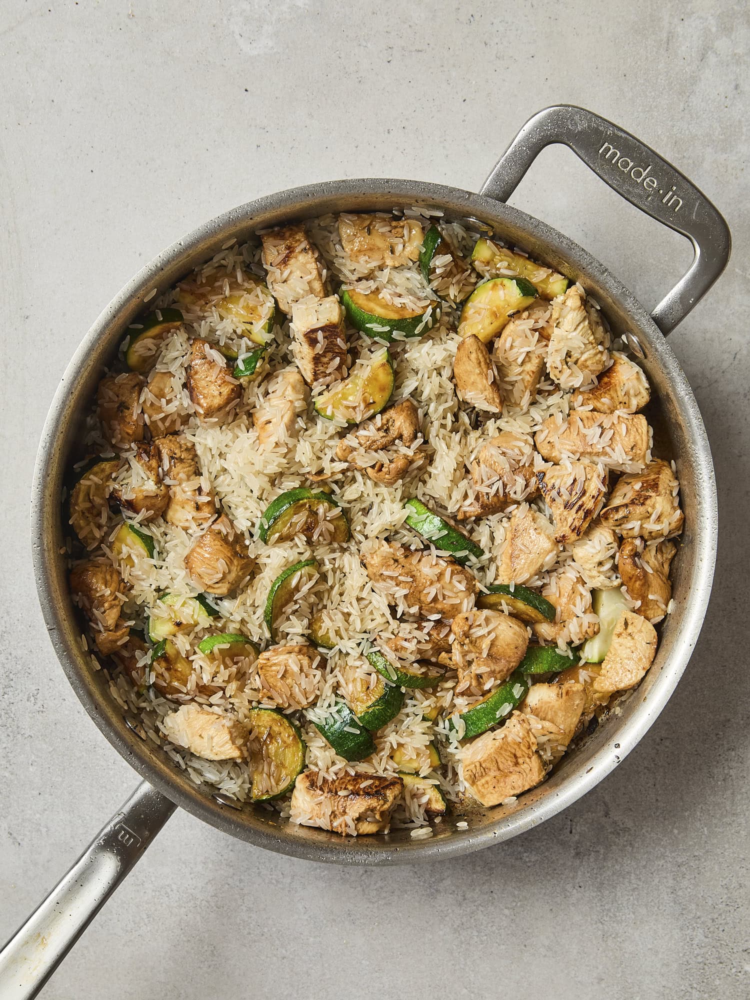 Browned chicken and zucchini mixed with rice.