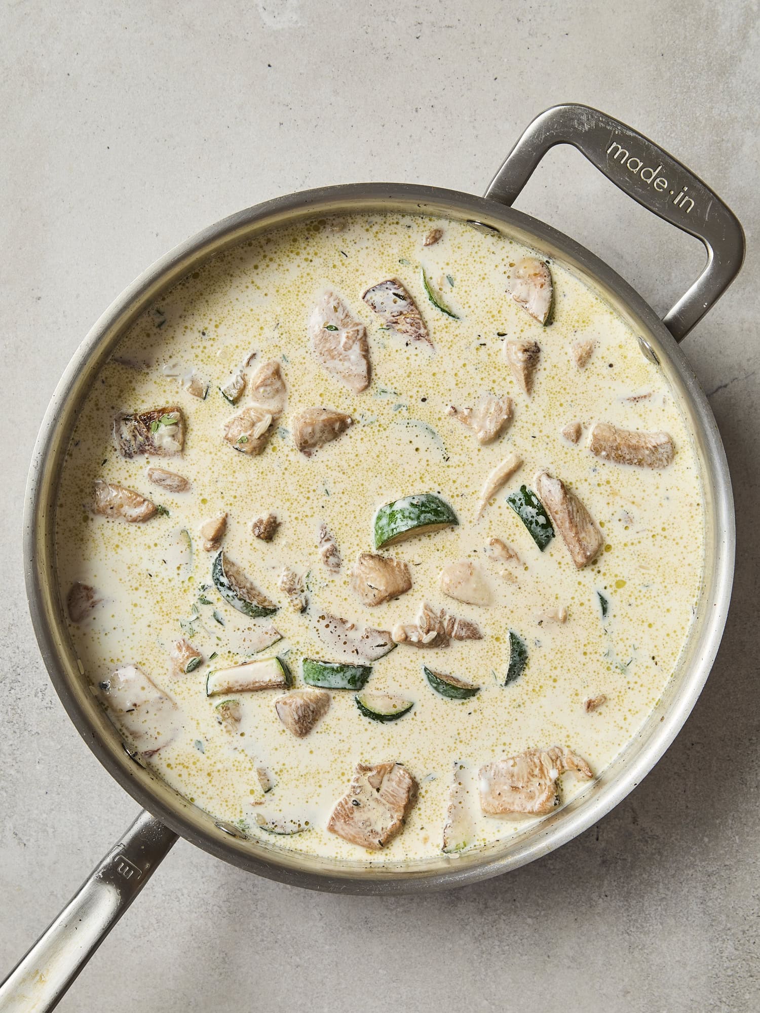 Cream mixture poured on top of chicken and zucchini for casserole.
