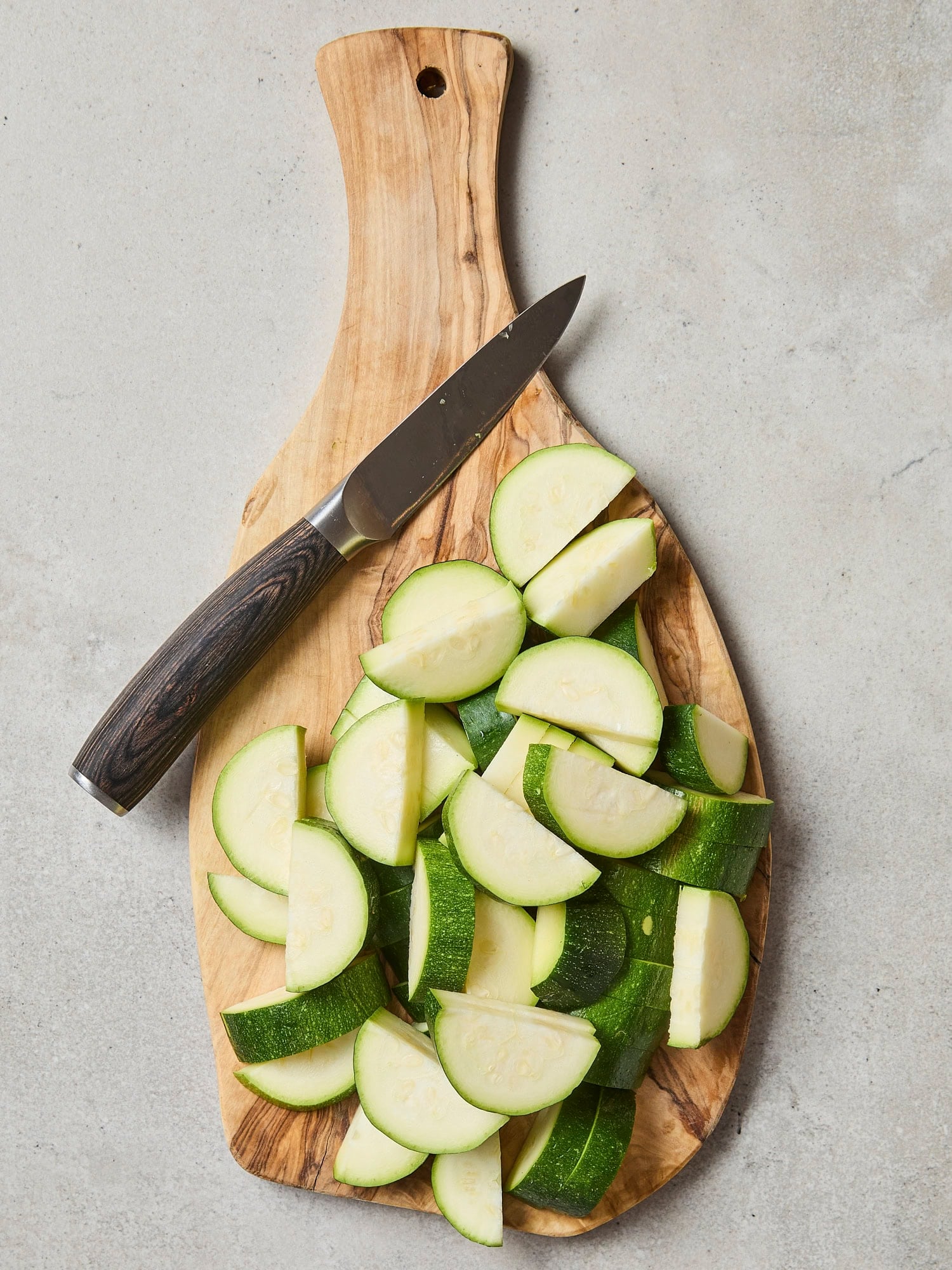 Cutting board with sliced zucchini.
