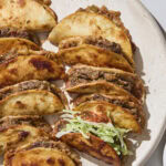 Platter filled with baked beef tacos.