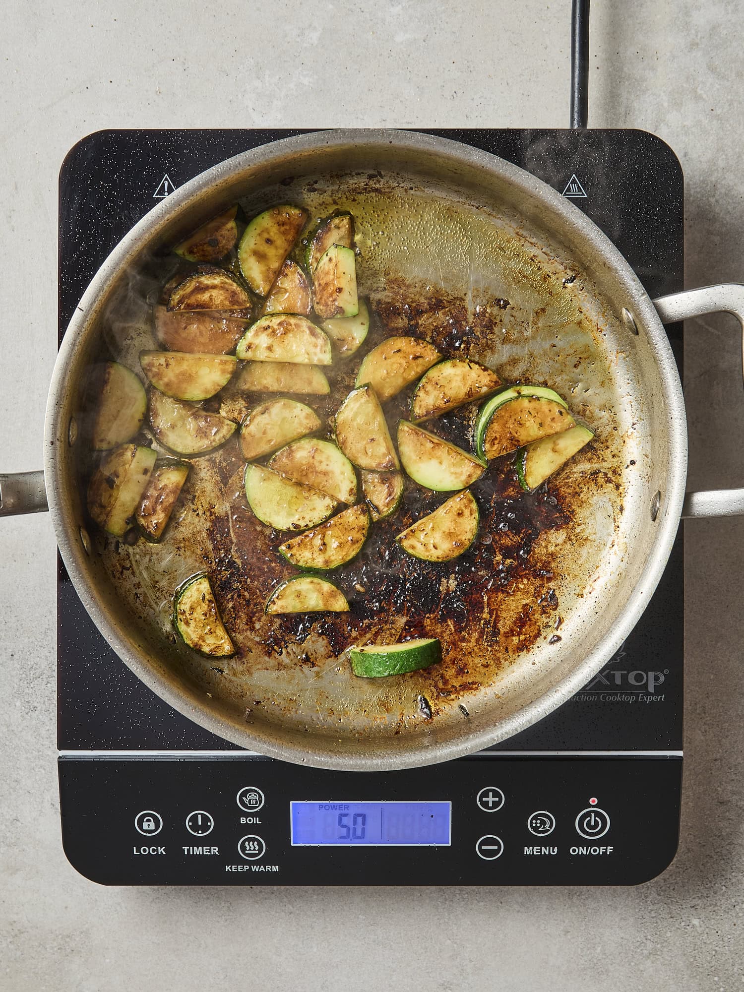 Pan with sautéd zucchini with brown edges.