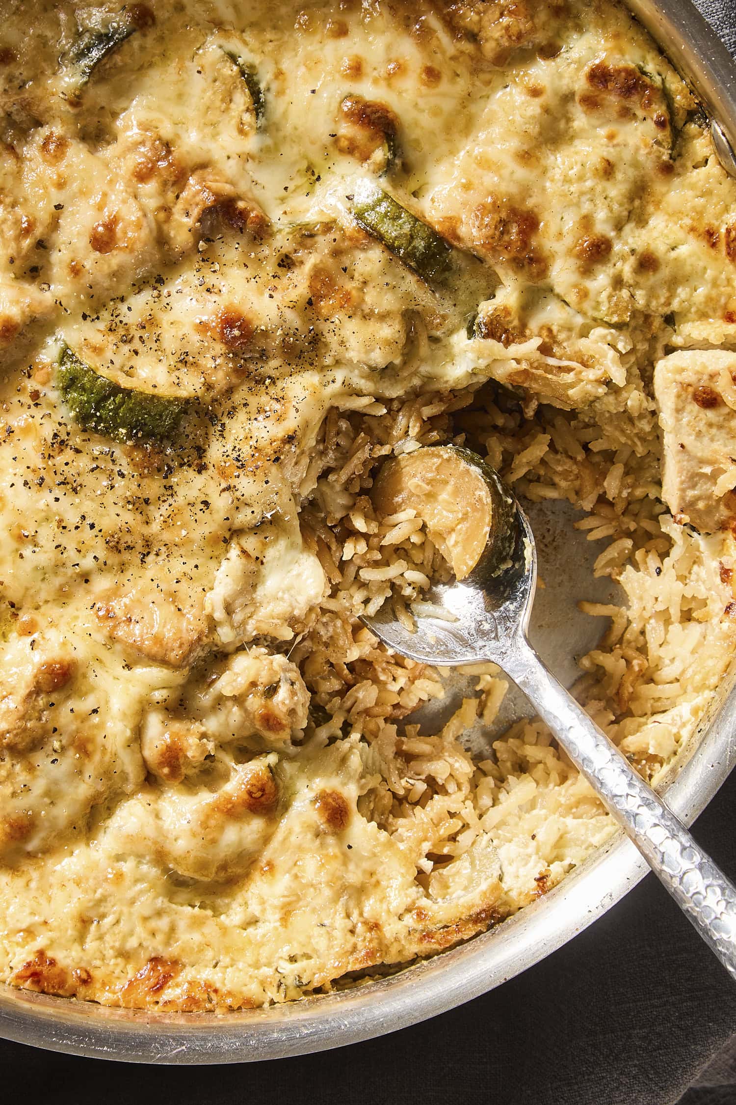 Chicken zucchini rice casserole with spoonful taken out showing rice interior.