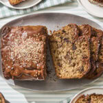 Sliced banana bread with chocolate chunks and tahini glaze.