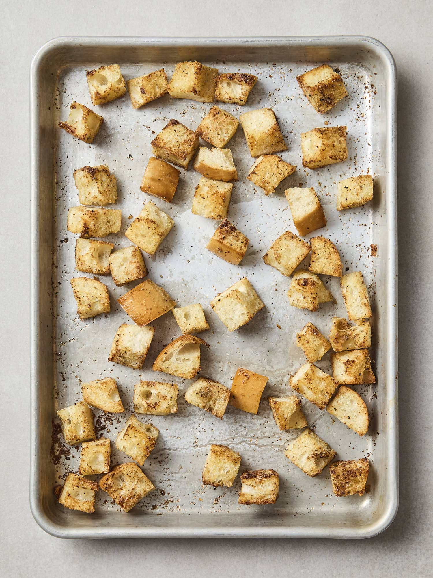 Baked homemade croutons on sheet pan.