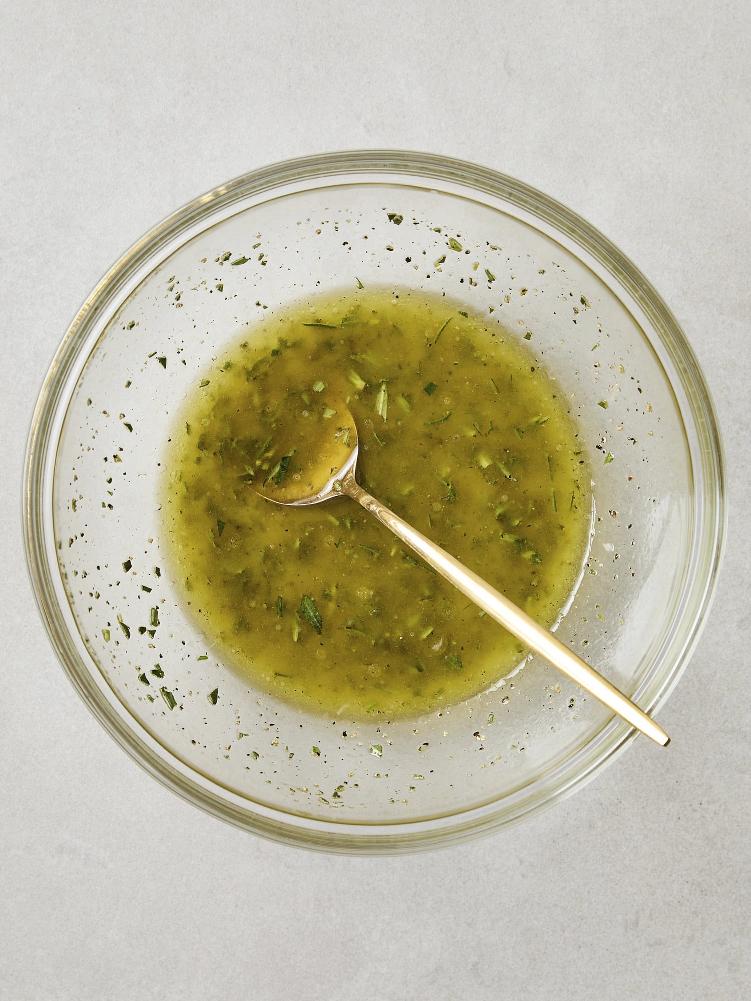 Glass bowl with marinade for chicken Caesar salad.