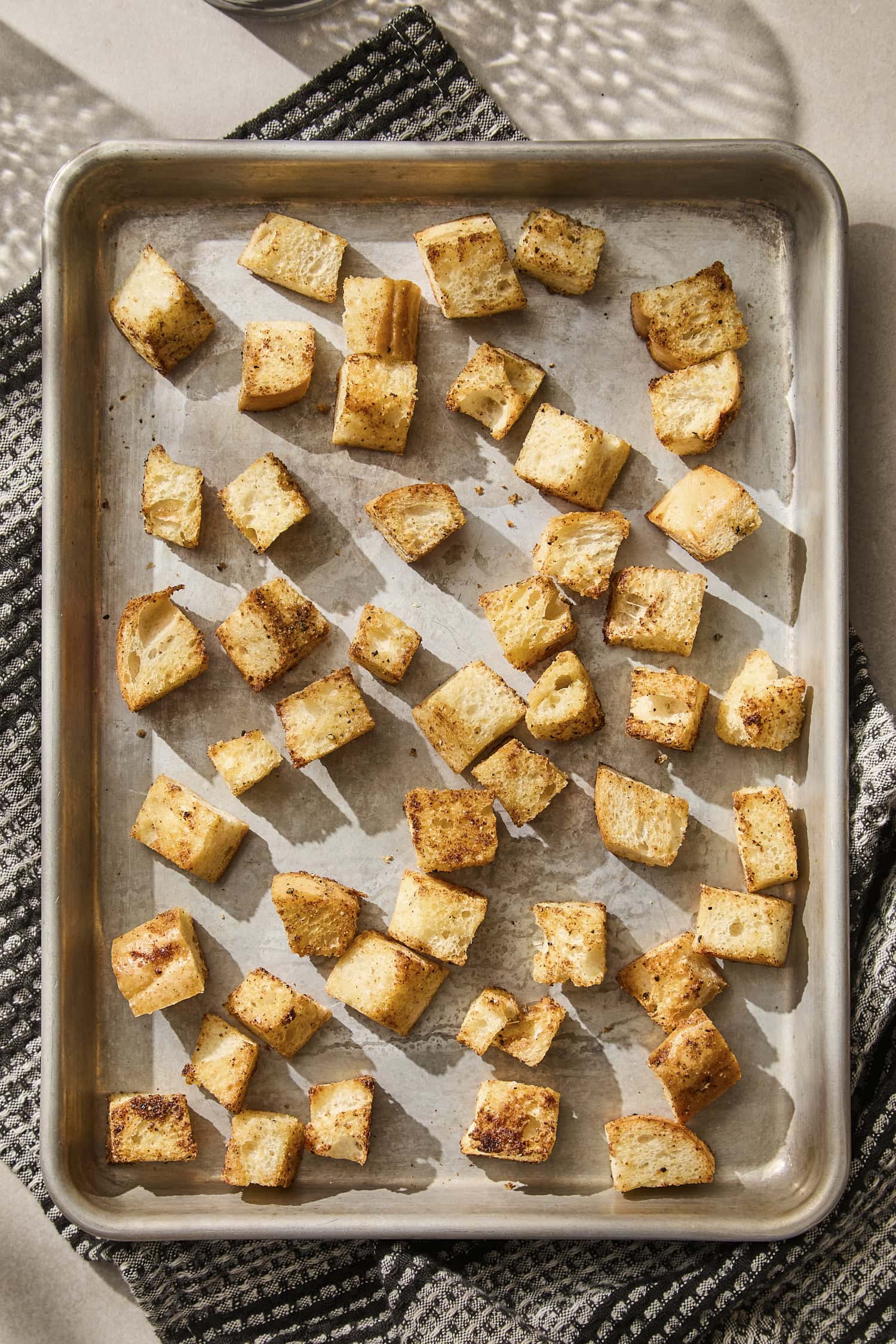 Baked homemade croutons on baking sheet.