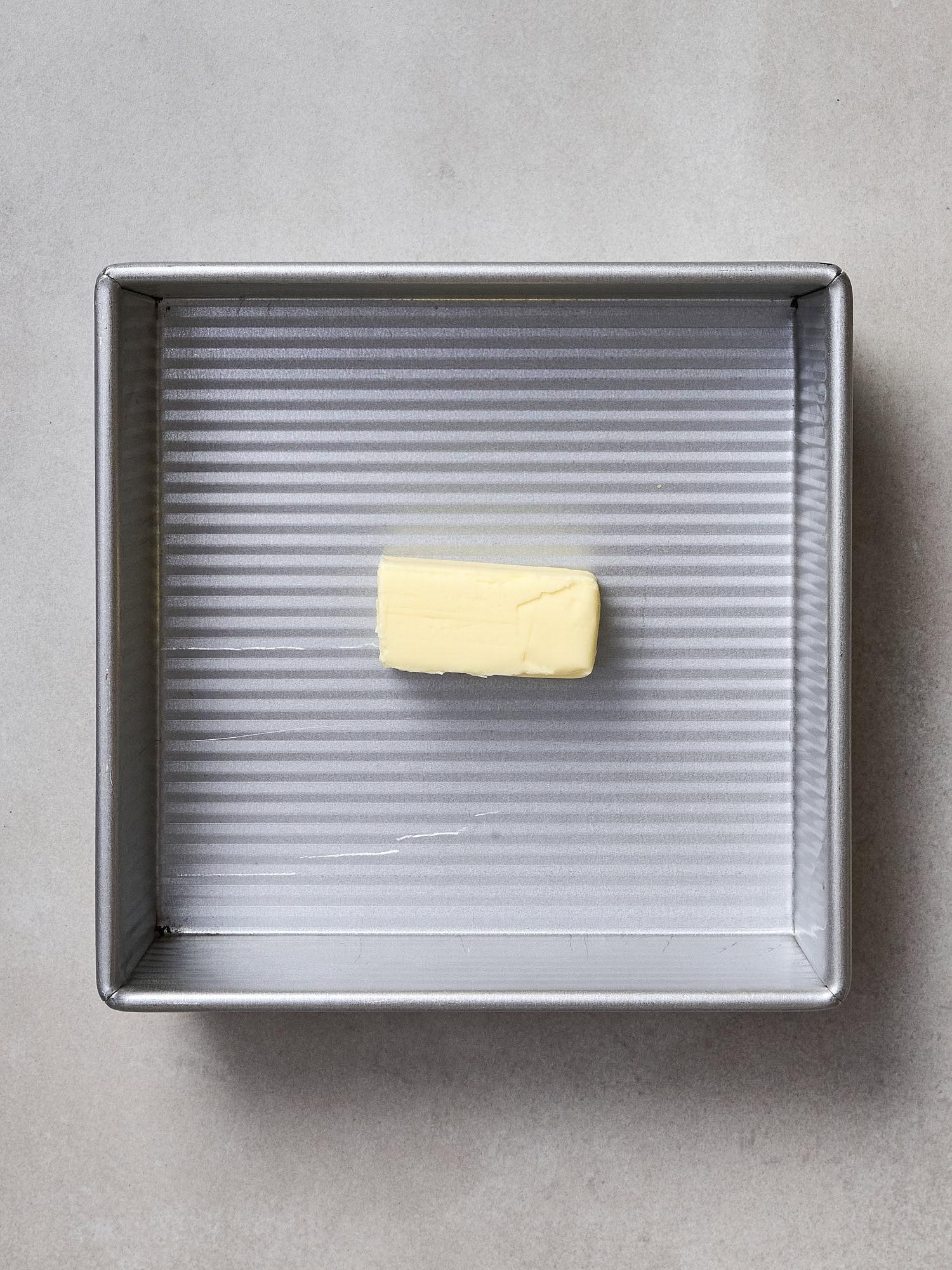 Unmelted stick of butter in a baking dish.