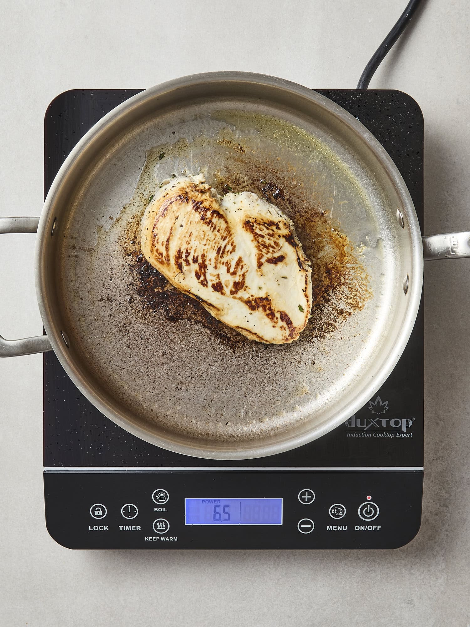 Seared chicken breast for chicken Caesar salad in pan.