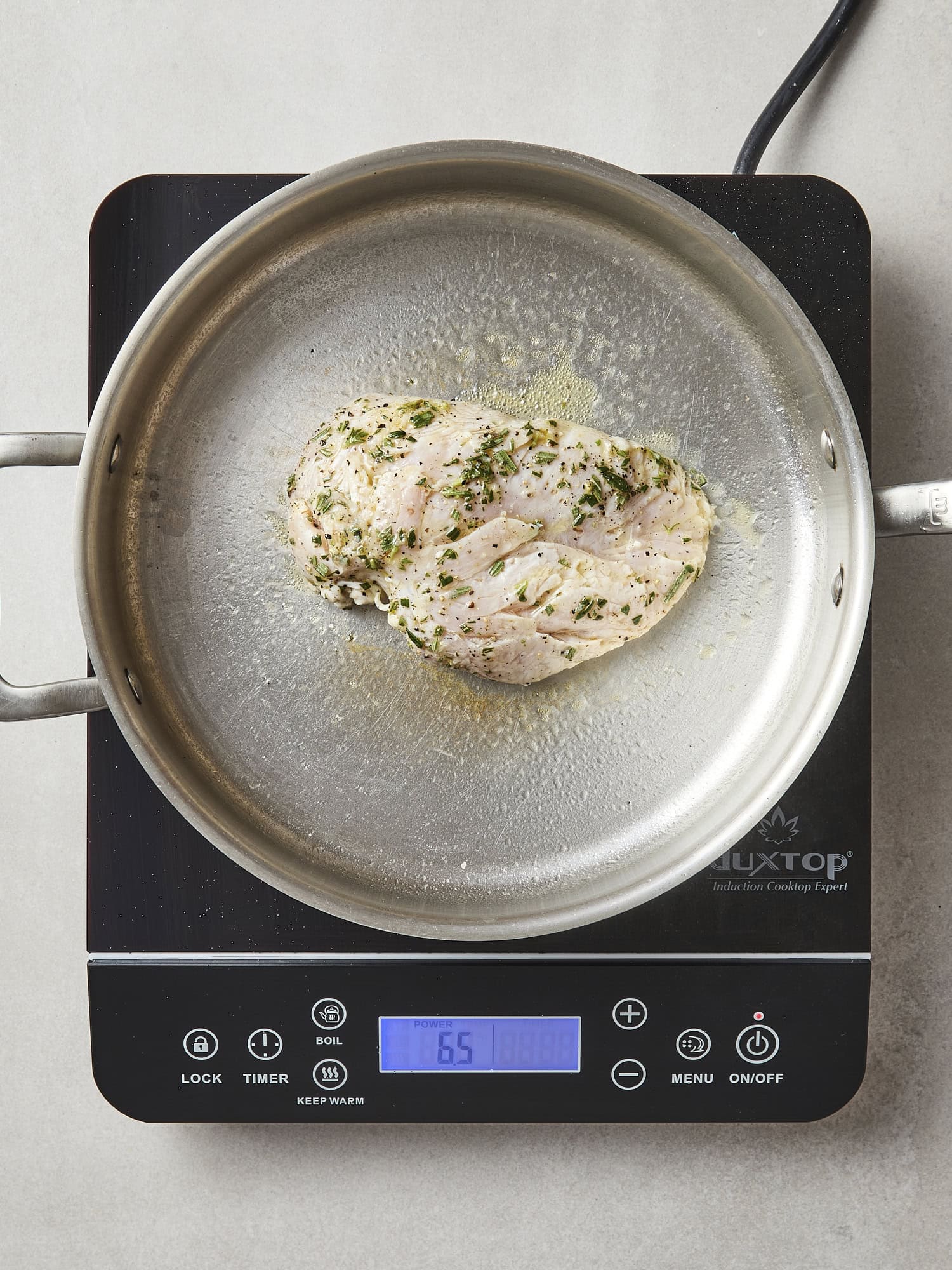 Uncooked marinated chicken cooking in pan.