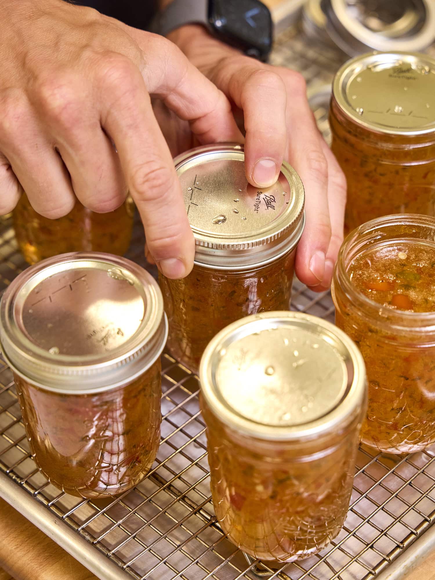 Adding a lid and ring to jam jar.