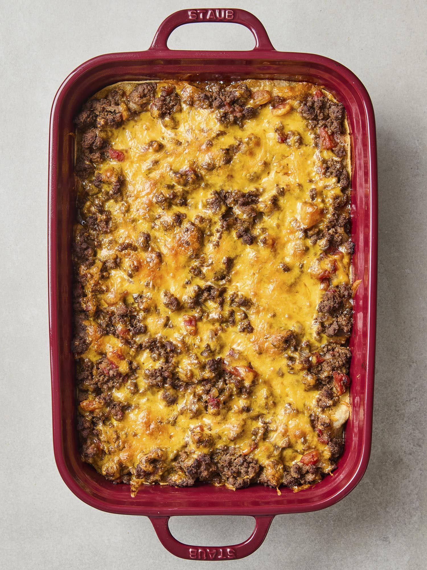 Baked taco casserole in red dish.