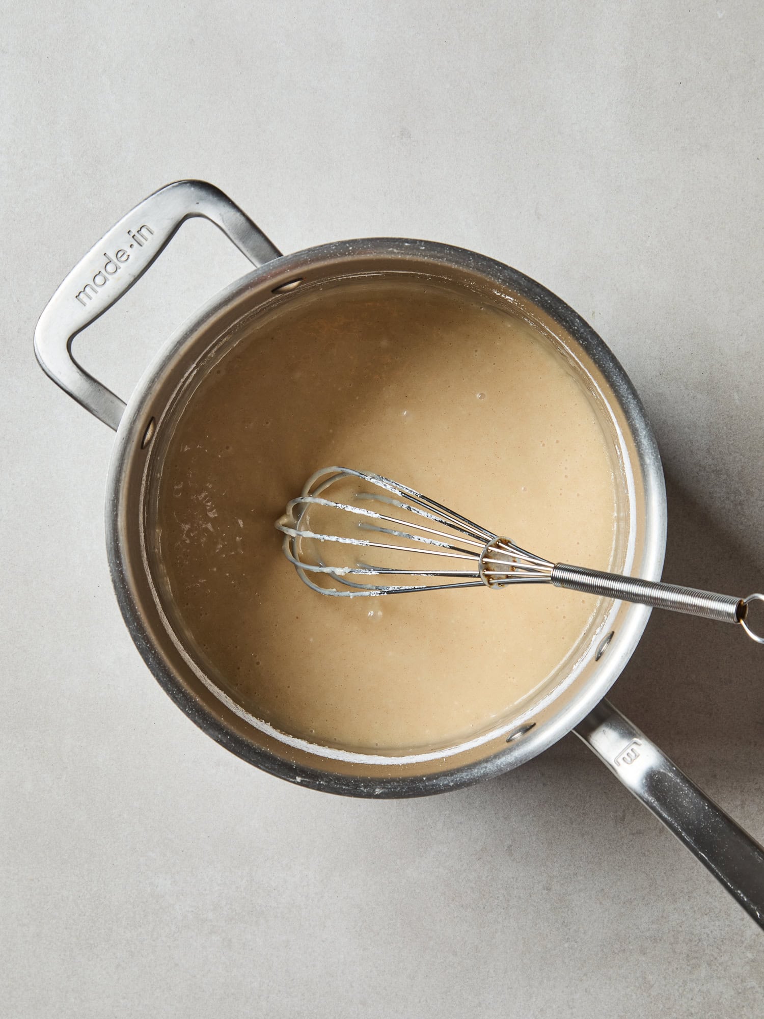 Brown butter frosting mixed together in a saucepan.