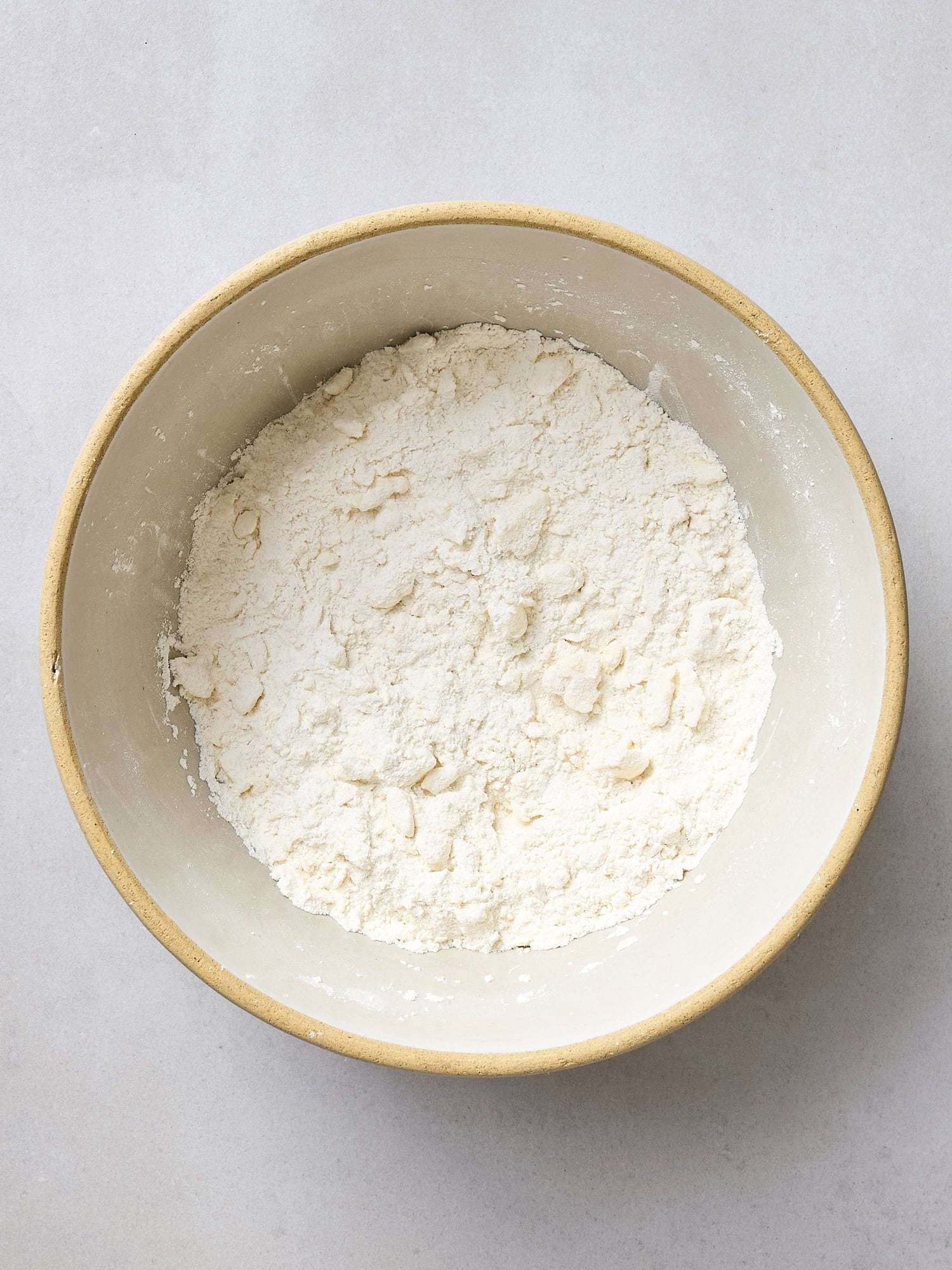 Butter pressed into dry ingredients for dough.