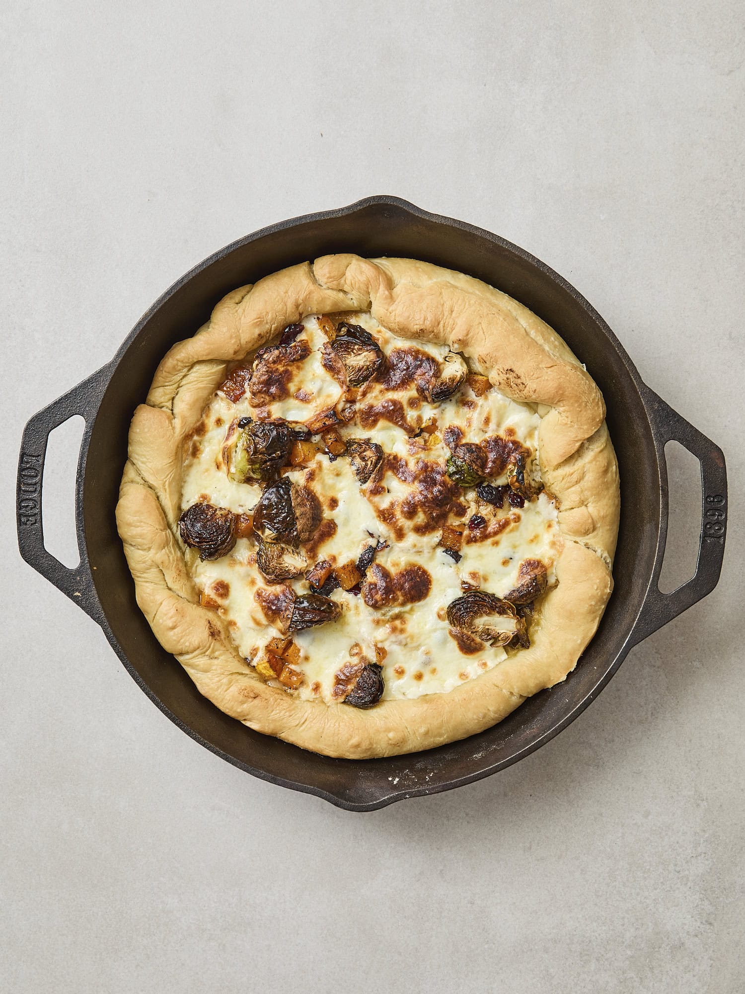 Baked butternut squash pizza with melted cheese on top.