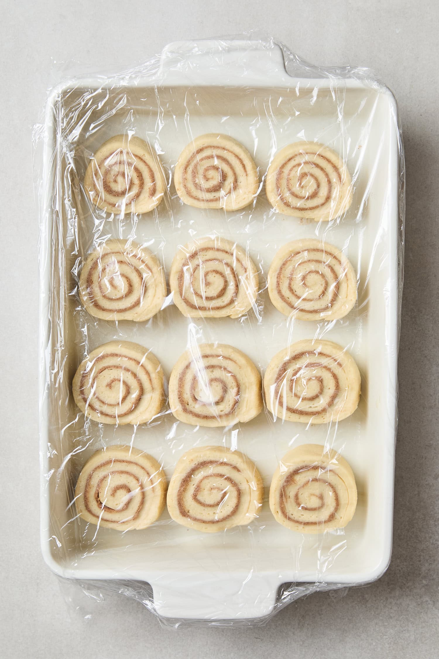 Sliced cinnamon rolls in a pan prior to rising.