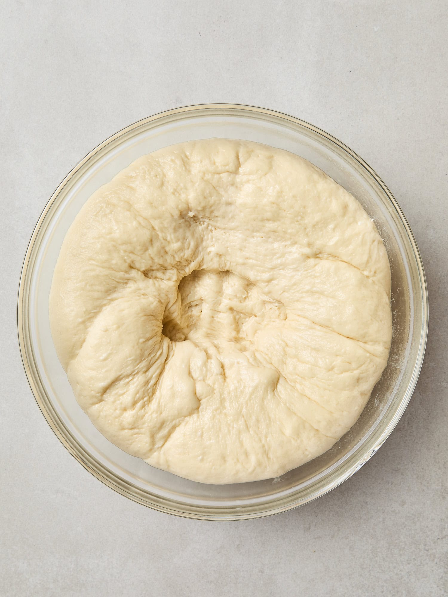 Punched-down dough in a bowl after rising.