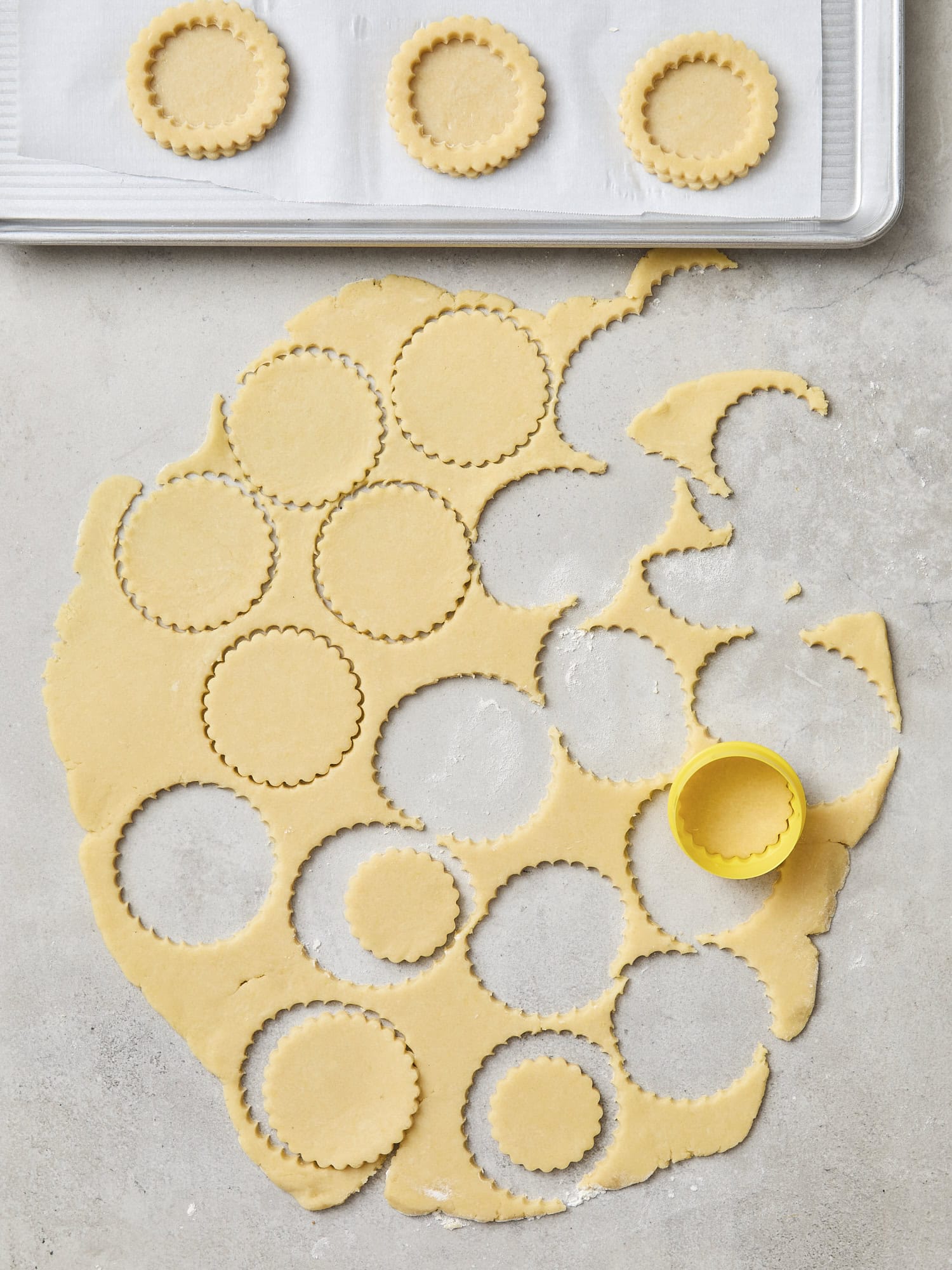 Cutting out the center pieces of dough for cookies.