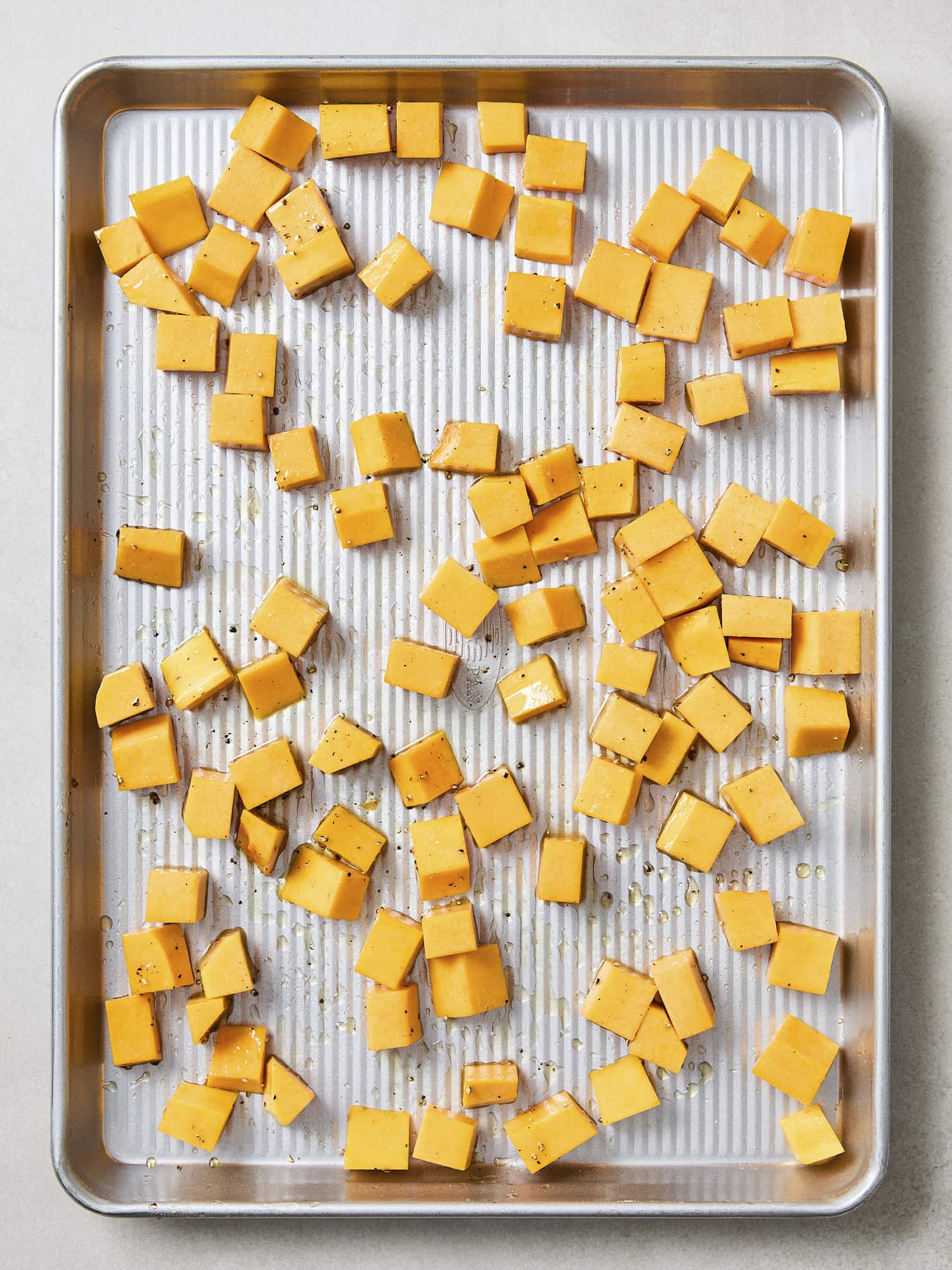 Diced butternut squash on sheet pan.