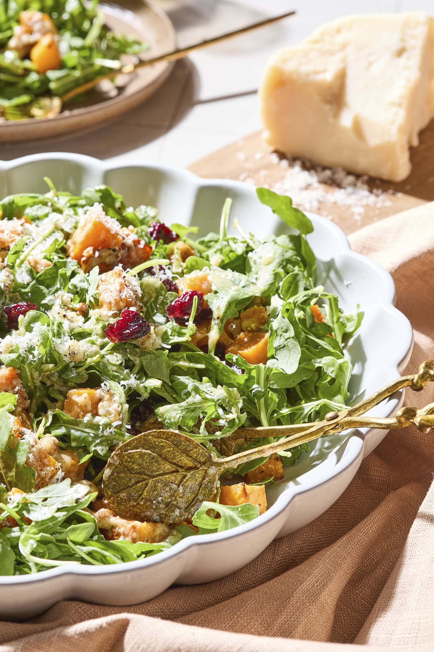 Butternut squash fall salad in a bowl with apple cider vinaigrette on top.