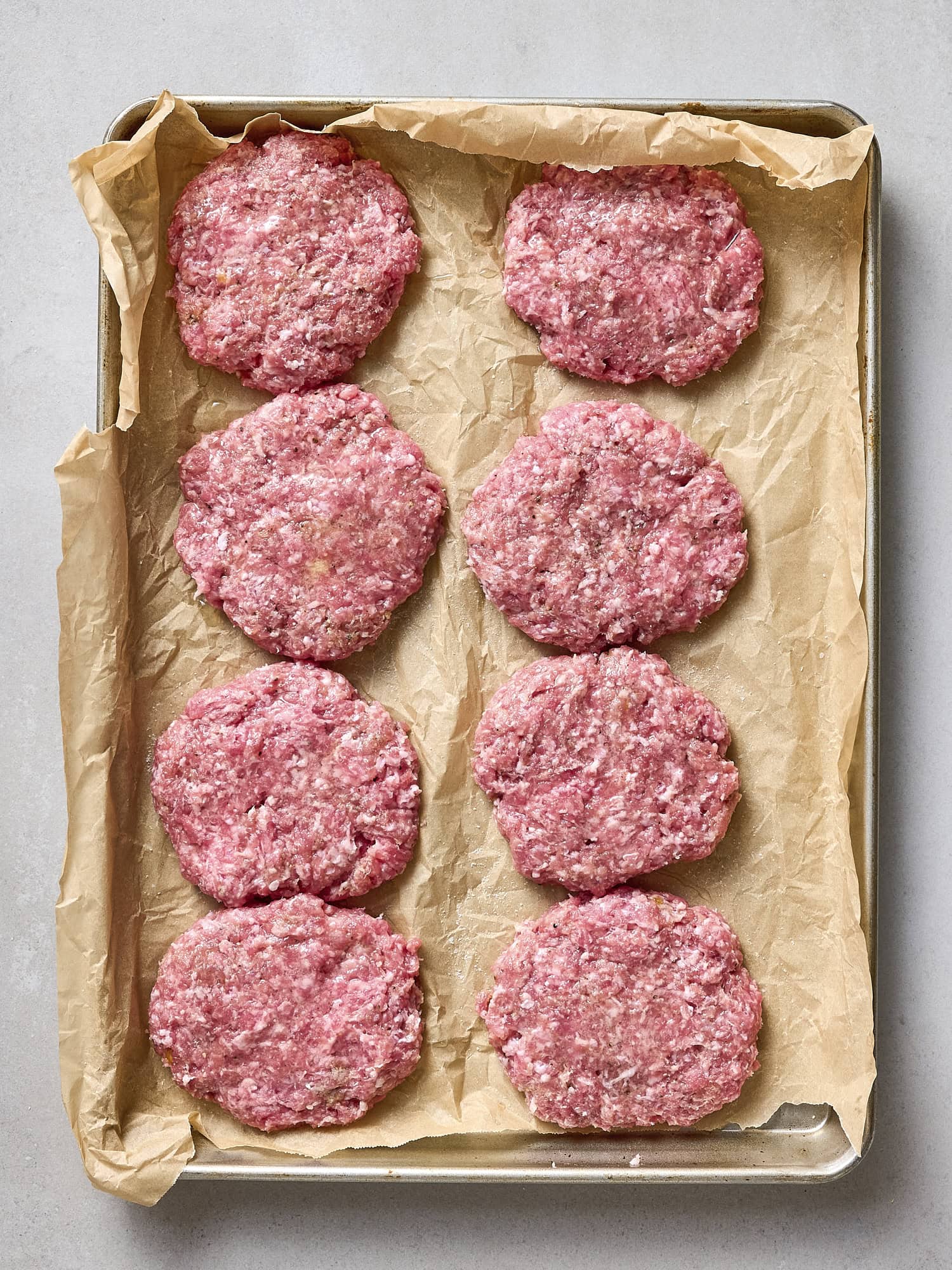 Formed pork burgers on sheet pan.