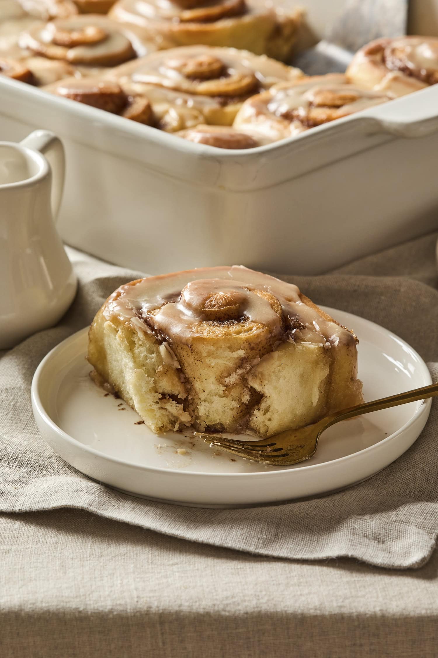 Bite taken out of cinnamon roll showing interior rolled texture.