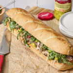 Italian pork sandwich assembled and ready to be sliced.