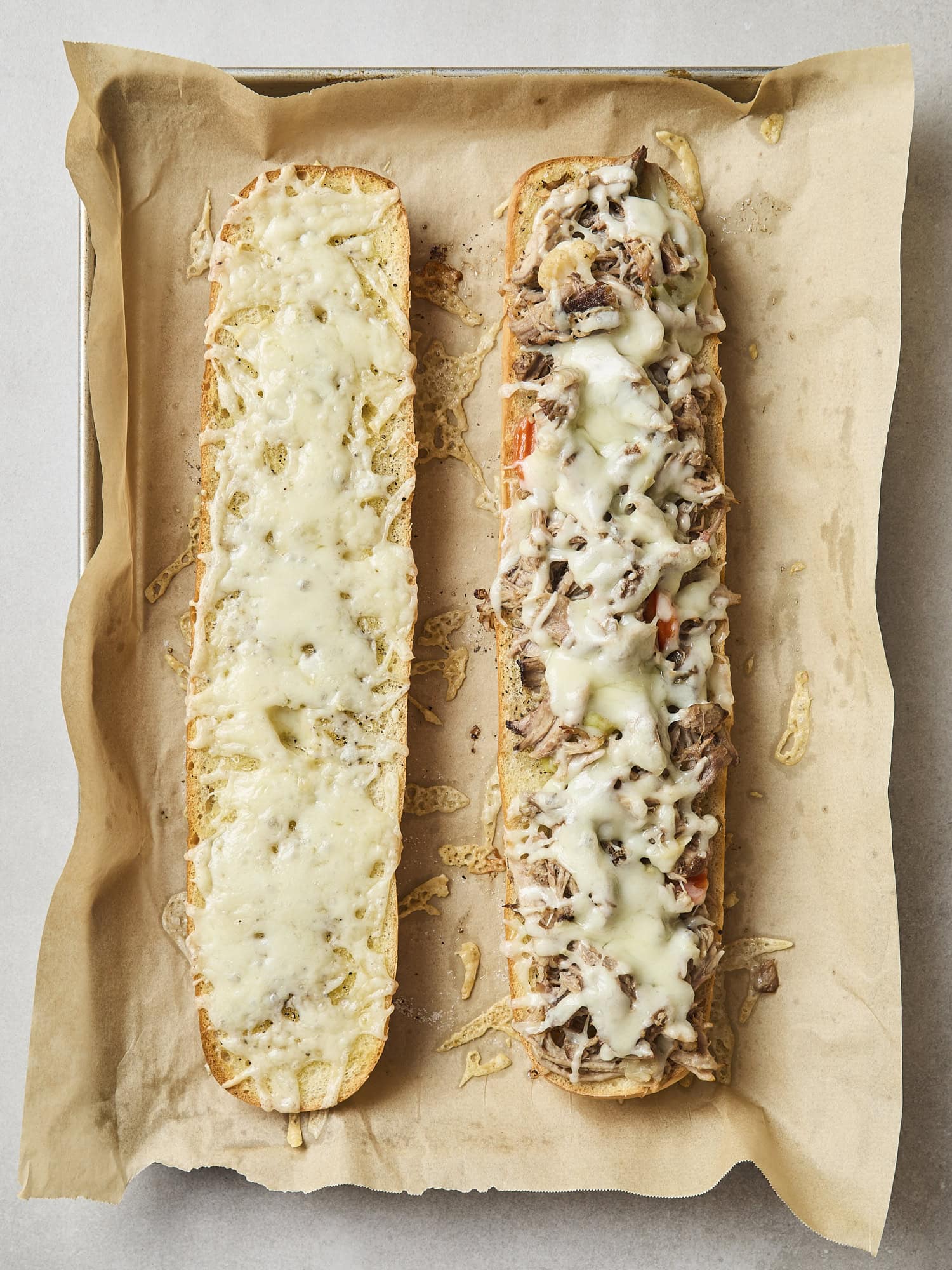 Melted cheese on top of pork on sandwich.