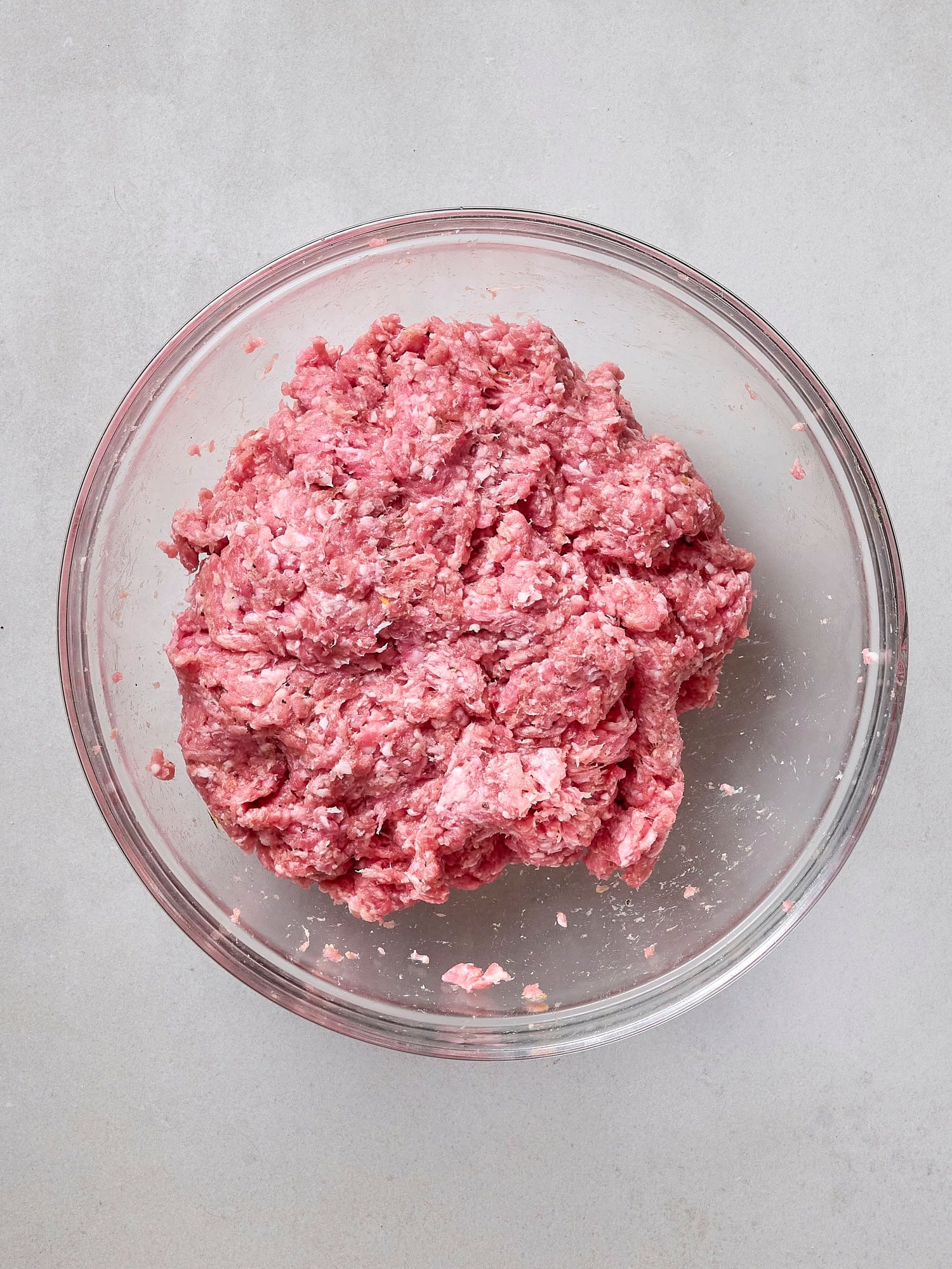 Glass bowl with pork burger mixture.