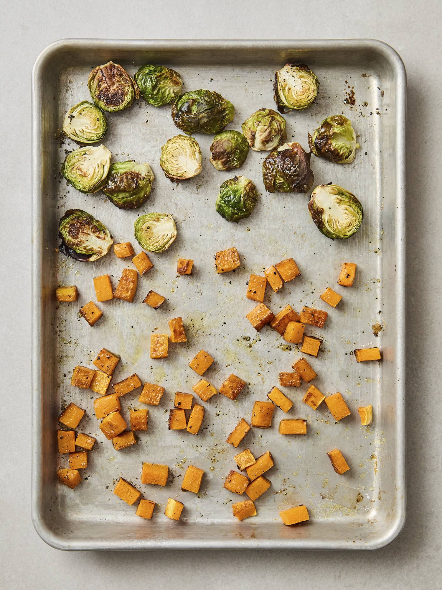 Sheet pan with roasted butternut squash and Brussels sprouts.