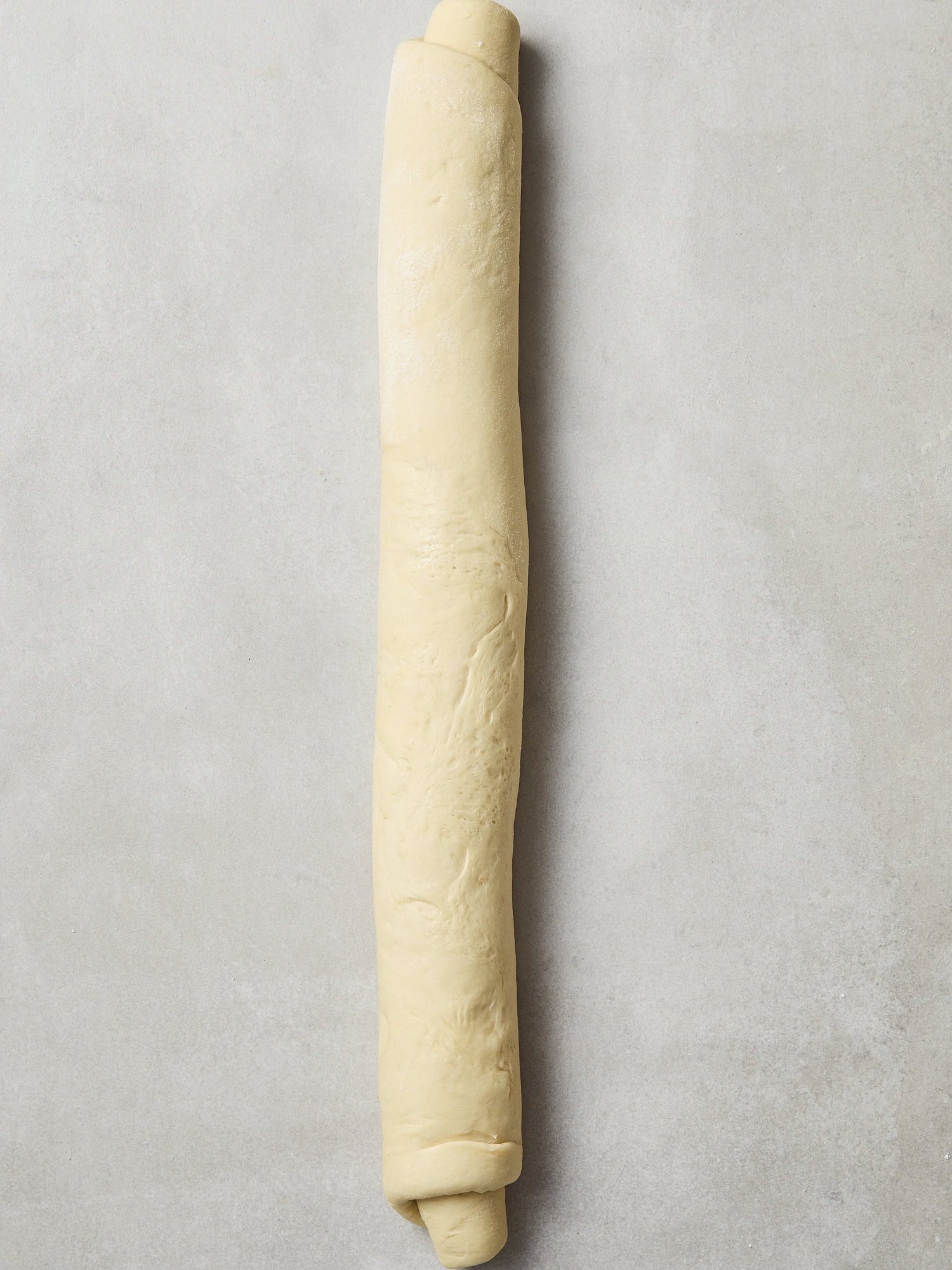 A cinnamon roll log prior to slicing.
