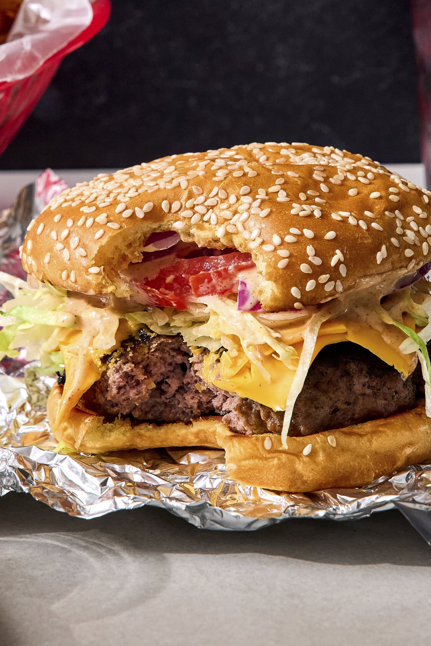 Grilled burger with bite taken out.