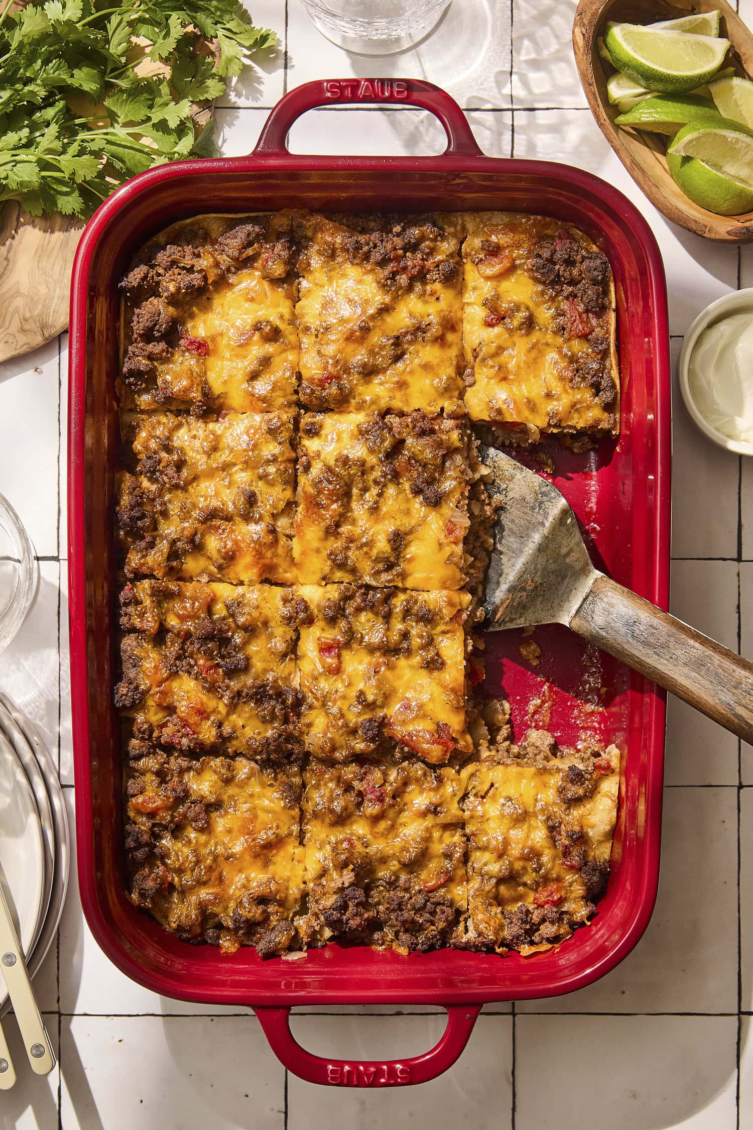 Baked taco casserole in red pan with slices cut.