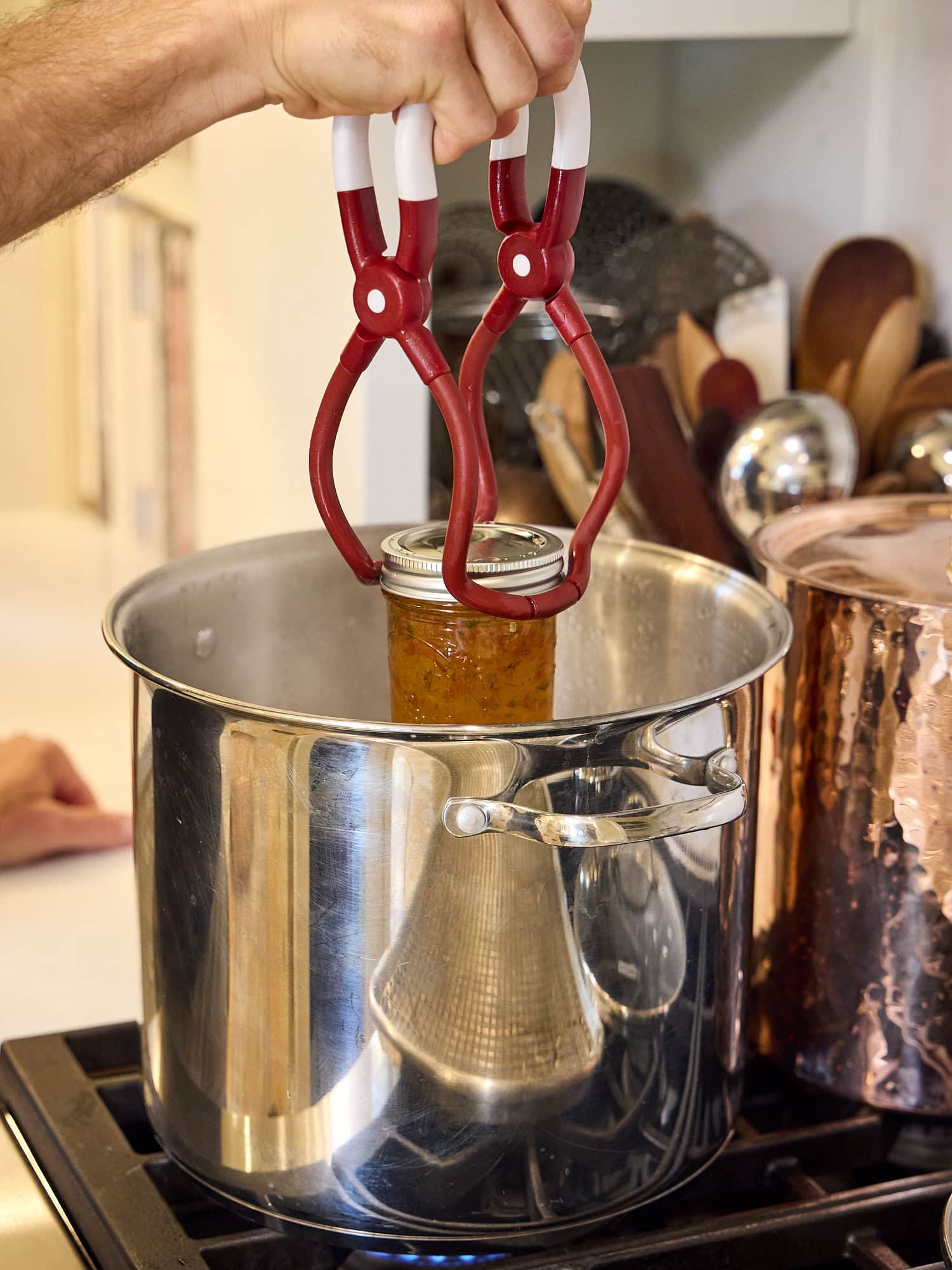 Adding jam jar to water bath.