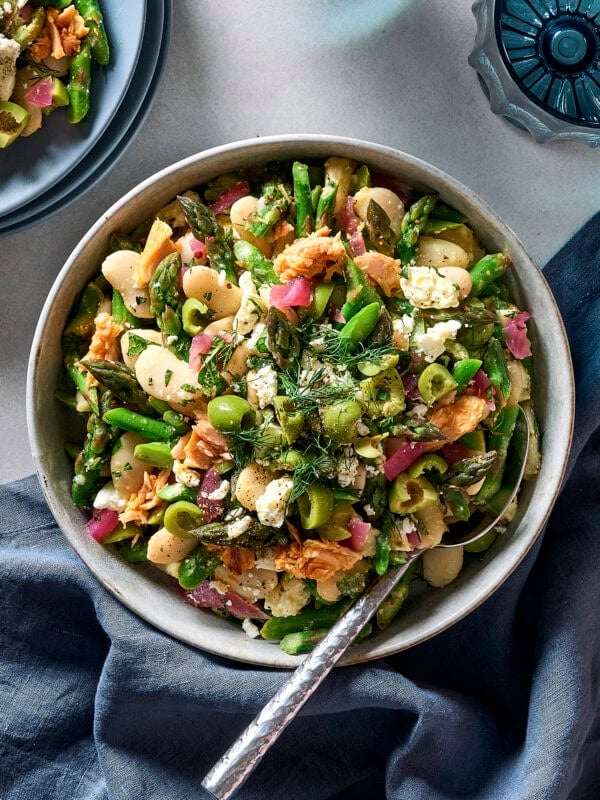 Bowl filled with asparagus white bean salad with feta and tuna on top.