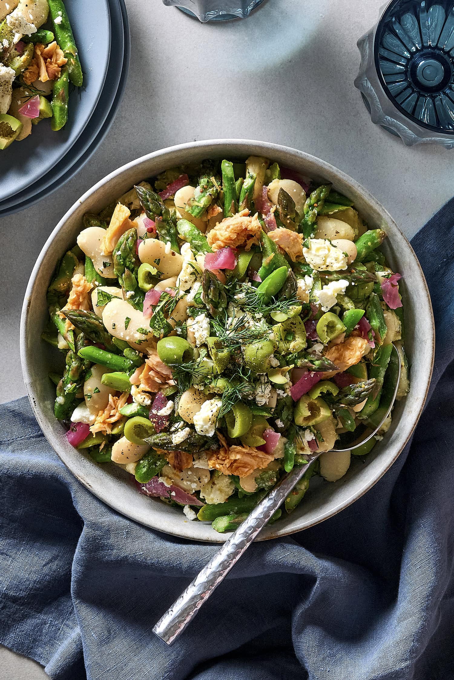 Bowl filled with asparagus white bean salad with feta and tuna on top.