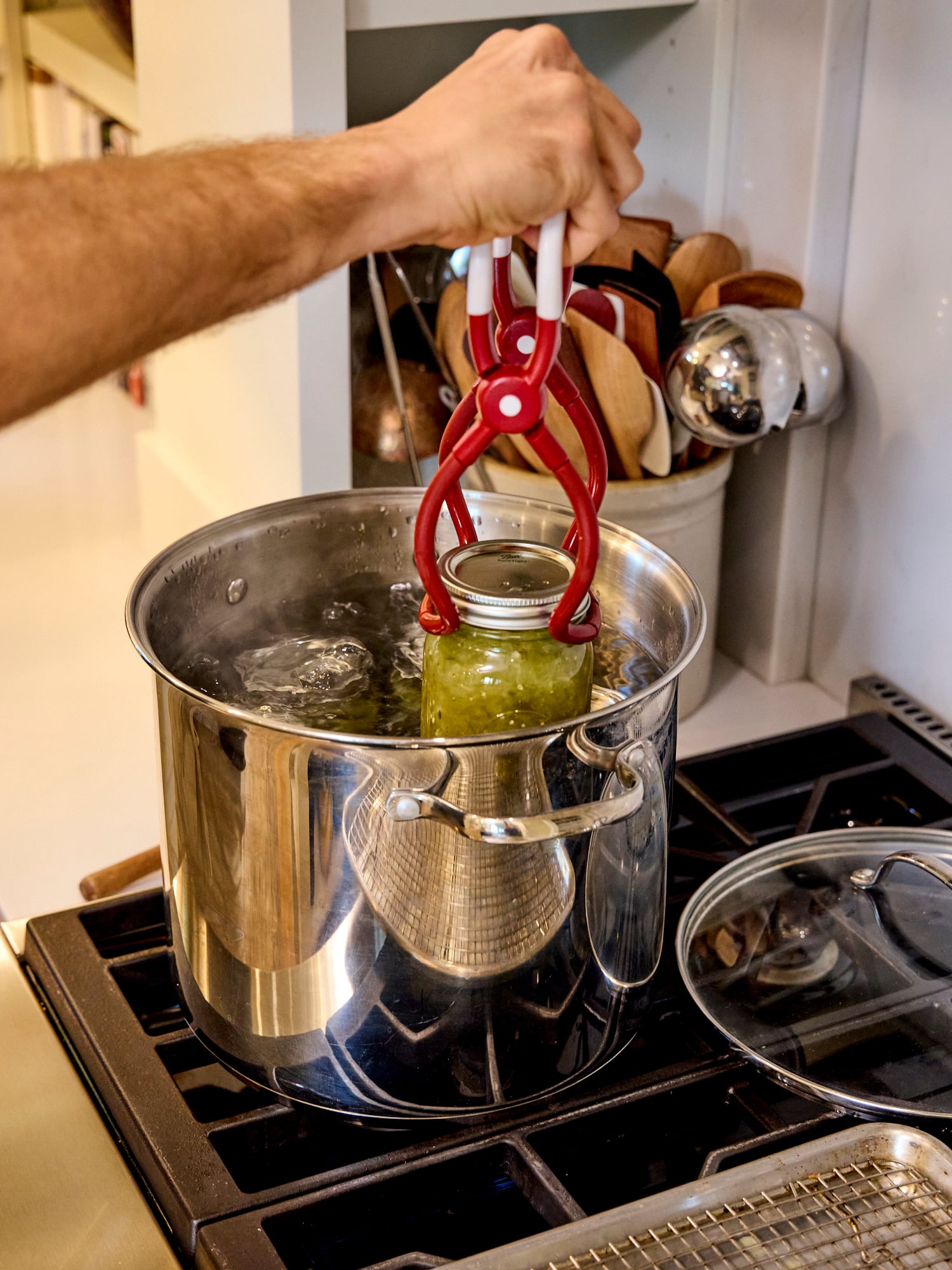 Adding jars to water bath canner to process.