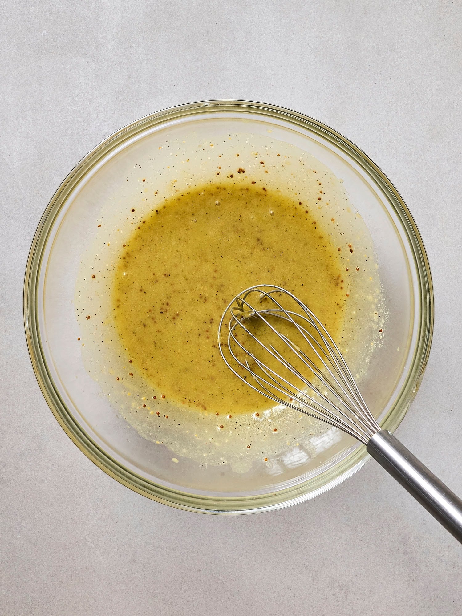 Whisking lemon Dijon dressing for asparagus white bean salad.