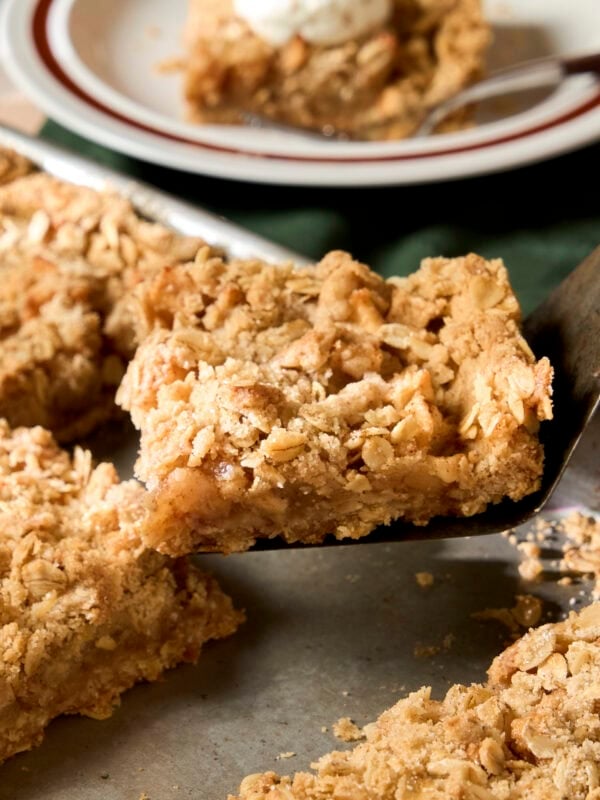 Spatula picking up a square of apple pie bars from pan.