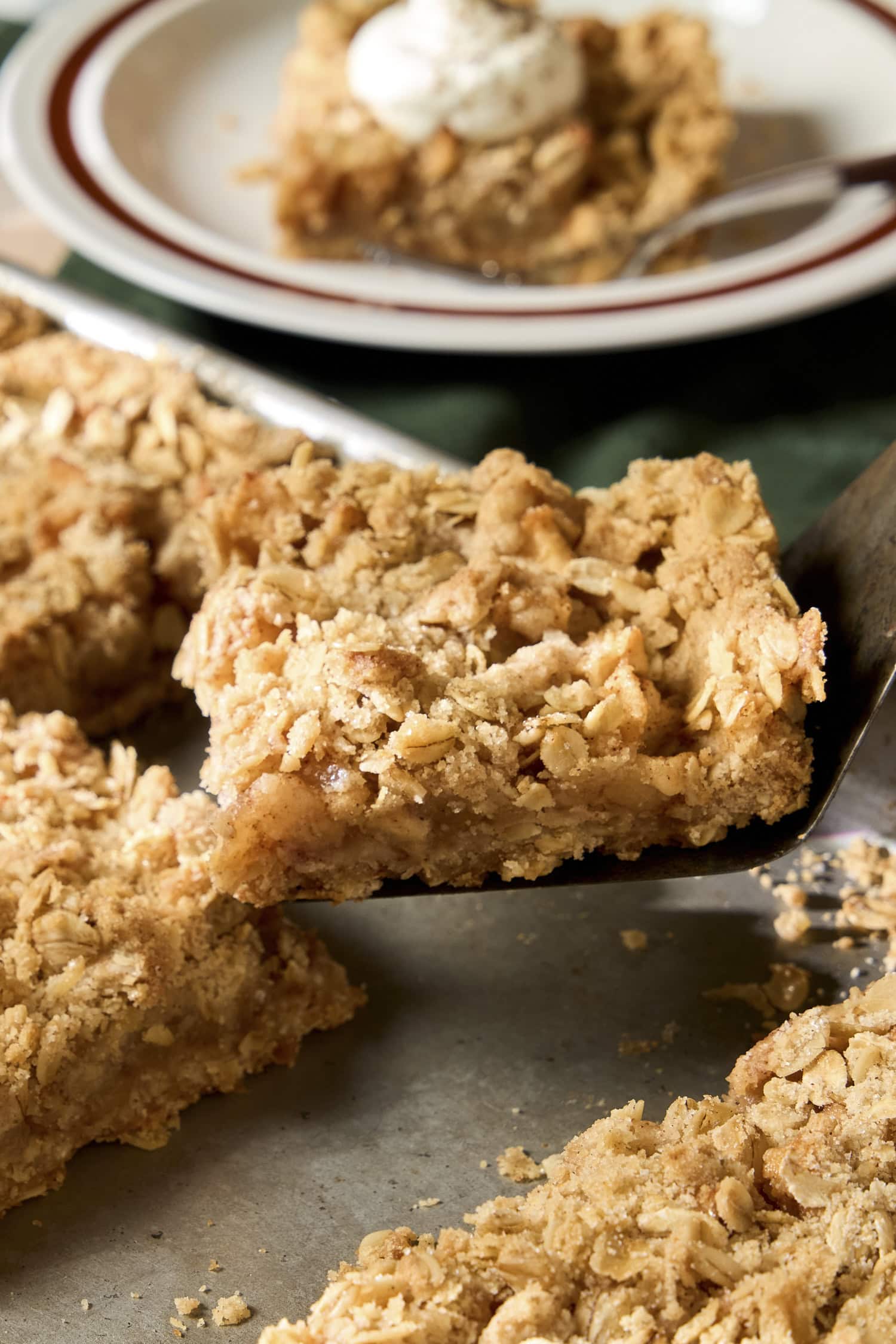 Spatula picking up a square of apple pie bars from pan.