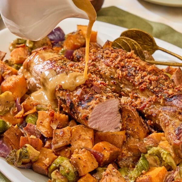Sauce pouring on top of maple glazed pork tenderloin.