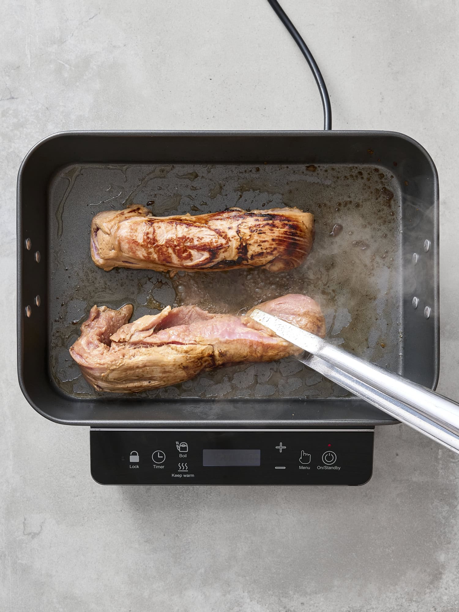 Searing pork tenderloins in a pan.