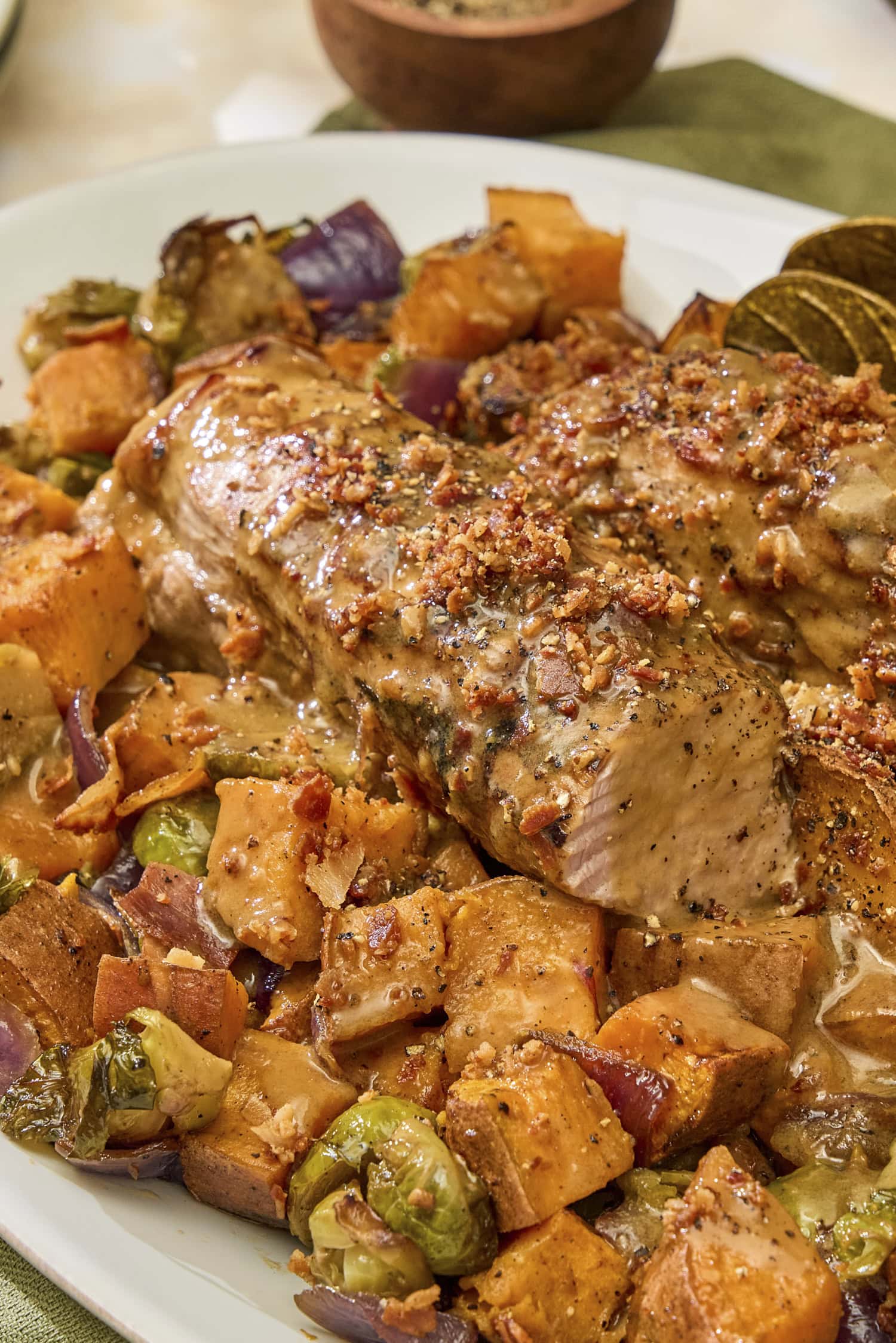 Glazed pork tenderloin with pancetta on top and roasted vegetables underneath for dinner.