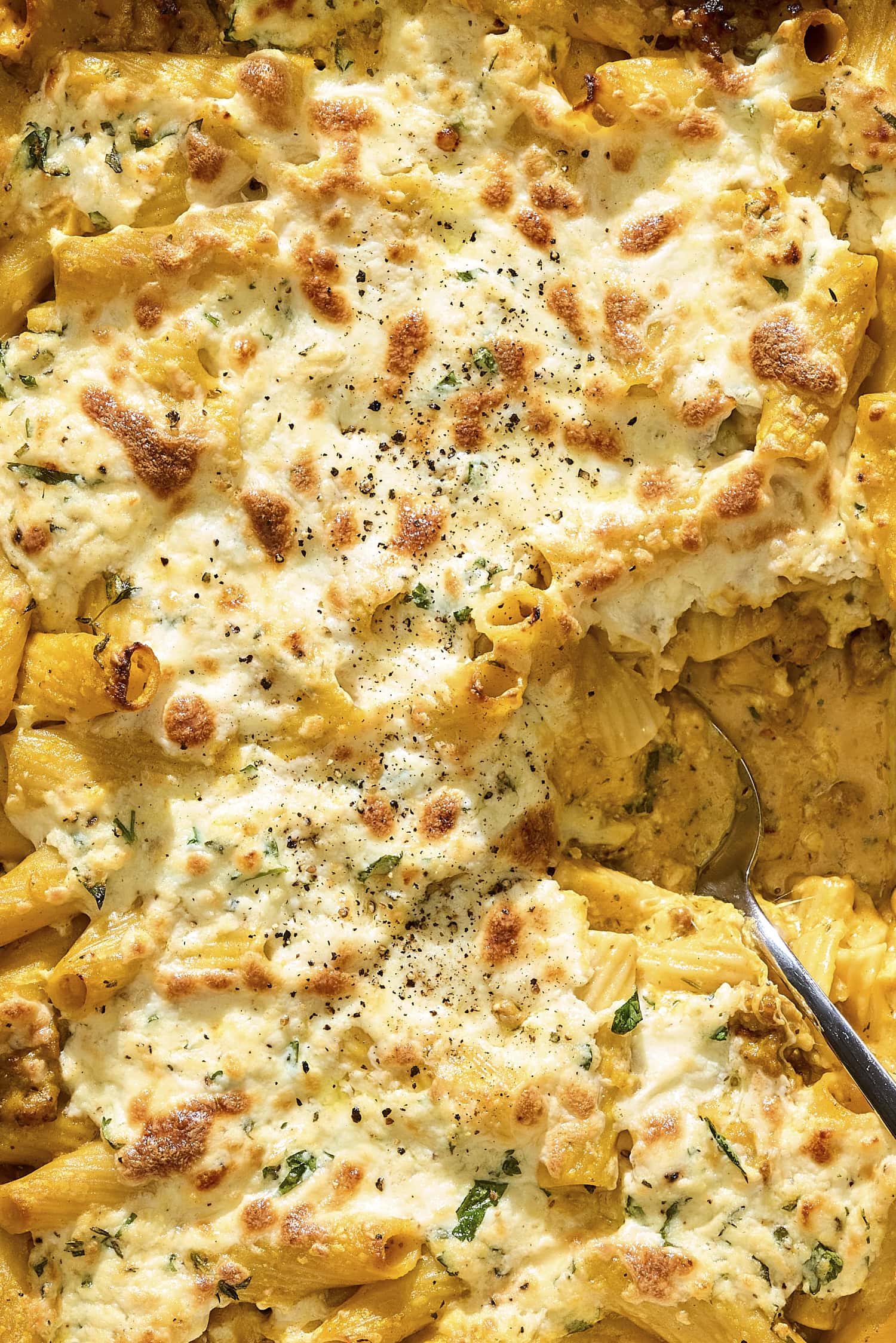Cheesy topping of baked ziti with pumpkin sausage sauce.