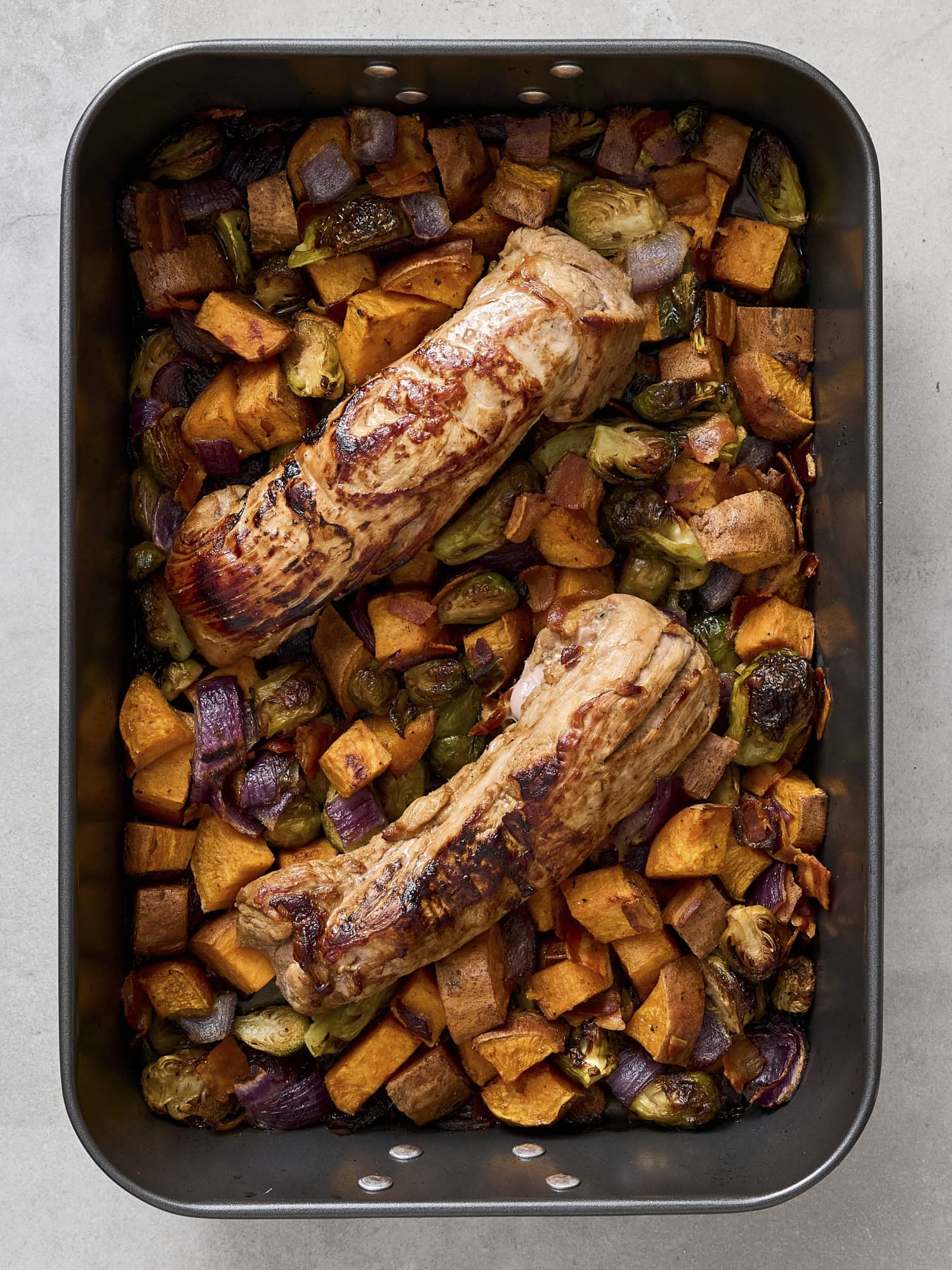 Fully cooked maple glazed pork tenderloin in pan.