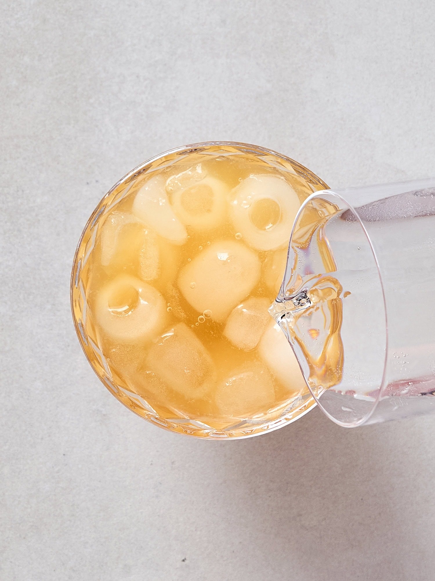Pouring sparkling apple cider into a margarita.