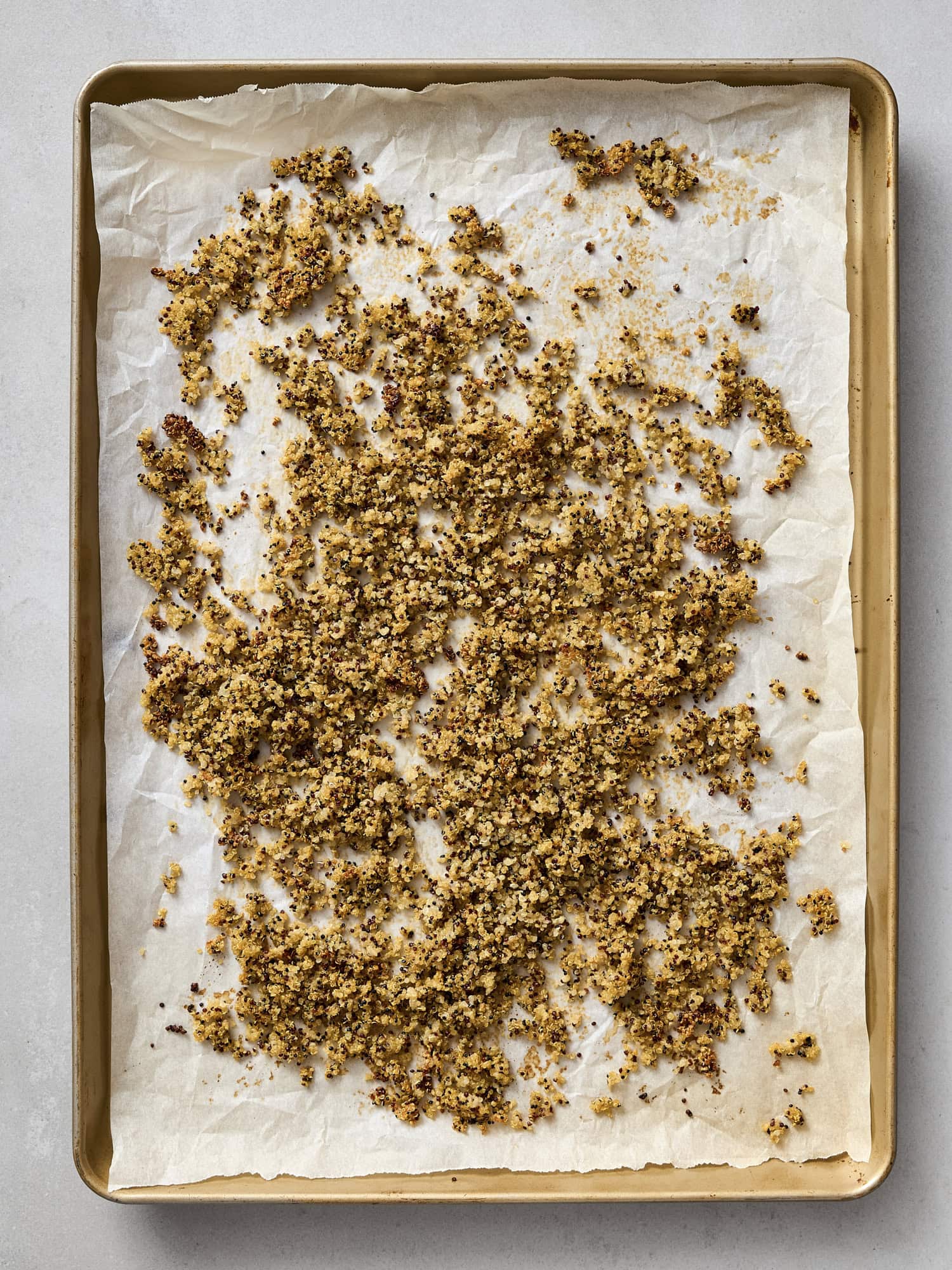 Baked crispy quinoa on baking sheet.