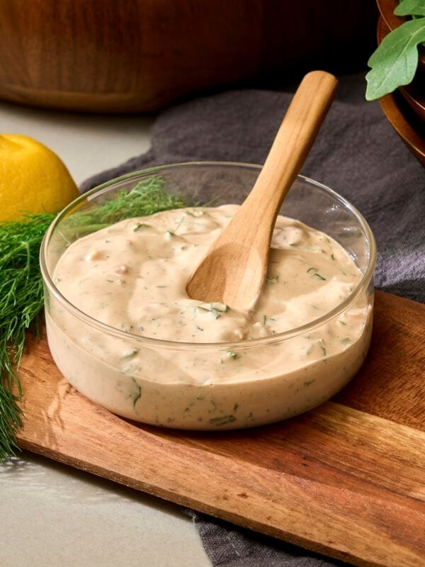Spoon in bowl of BBQ ranch dressing.