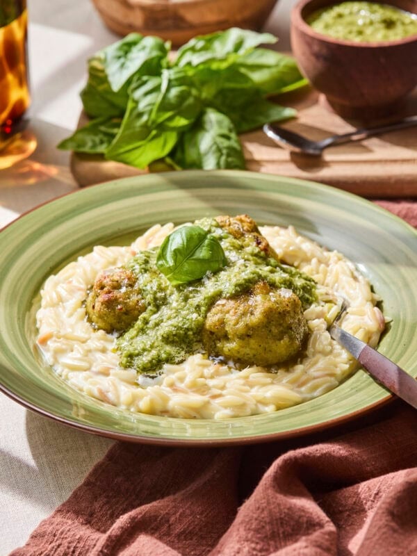 Pesto on top of chicken meatballs on bed of creamy orzo.