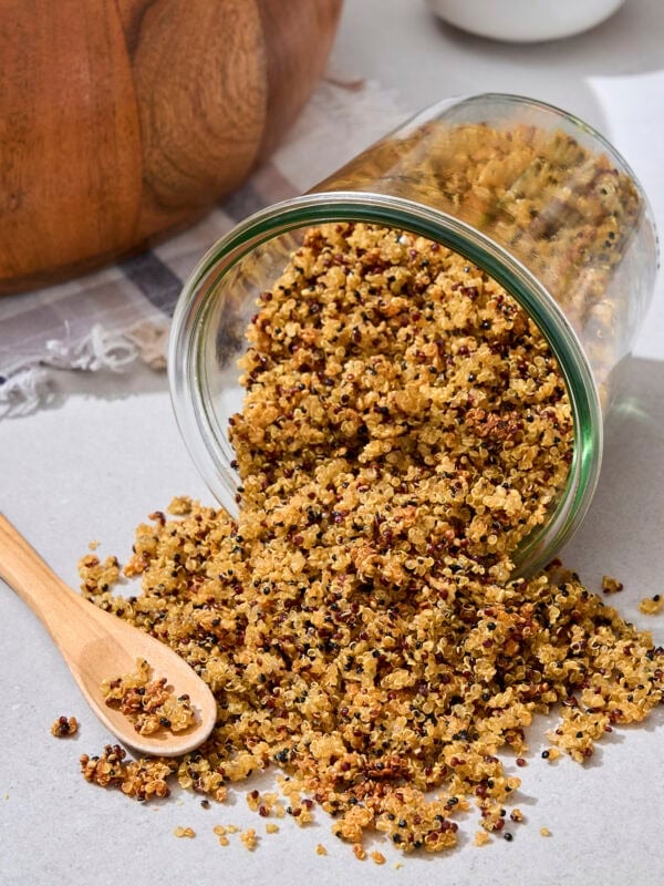 Jar on its side with crispy quinoa tumbling out.